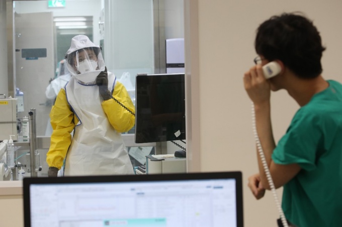 서울아산병원 의료진이 전화를 사용한 코로나19 확진자 문진을 실시하고 있다.