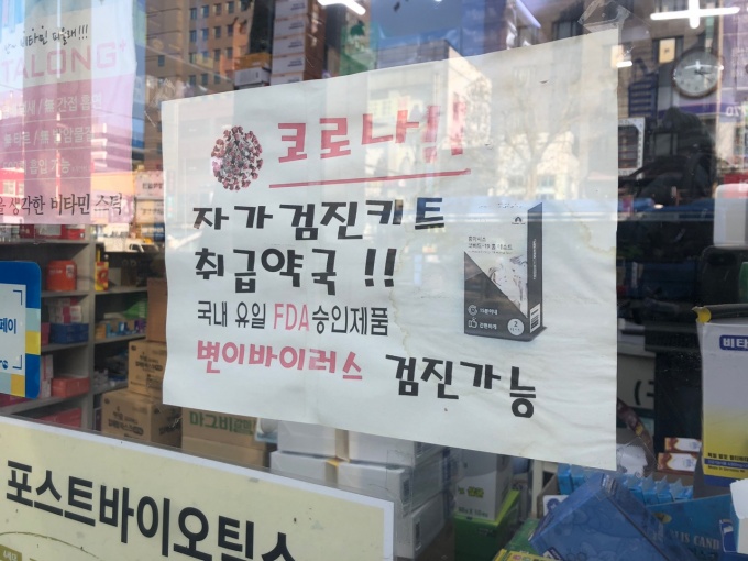 서울 종로구 한 약국 유리문에 붙은 자가진단키트 취급 안내문구.